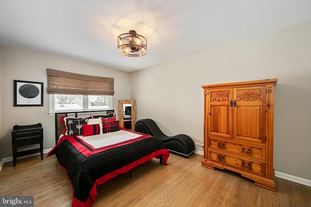 bedroom featuring a chandelier and light wood-type flooring