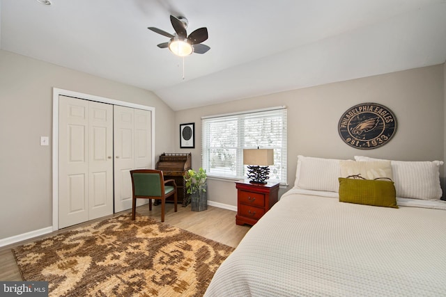 bedroom featuring ceiling fan, lofted ceiling, light hardwood / wood-style floors, and a closet