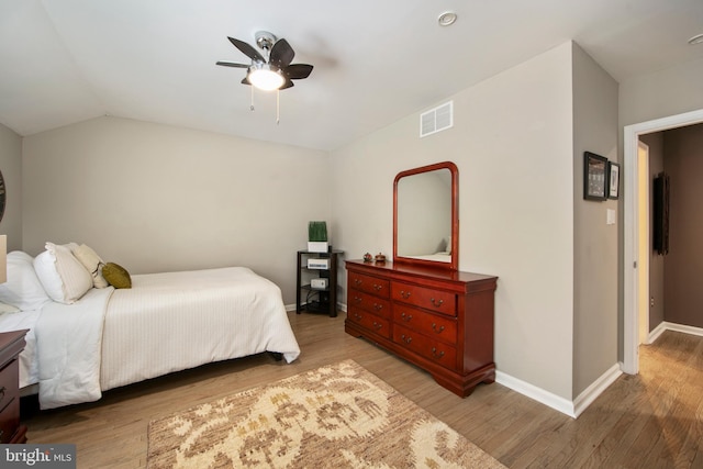 bedroom with hardwood / wood-style flooring, vaulted ceiling, and ceiling fan