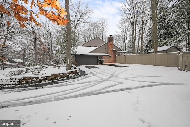 snowy yard with a garage