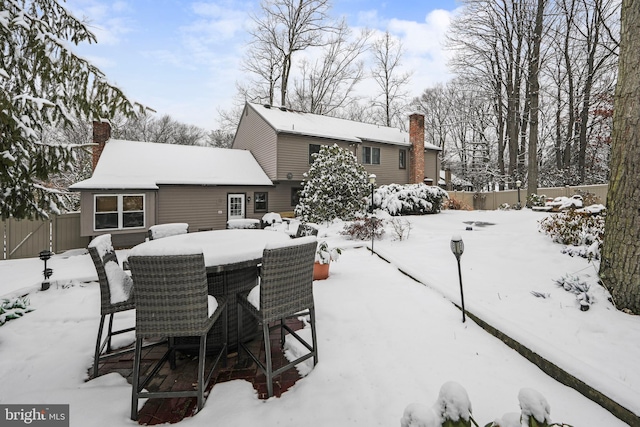 view of snow covered rear of property