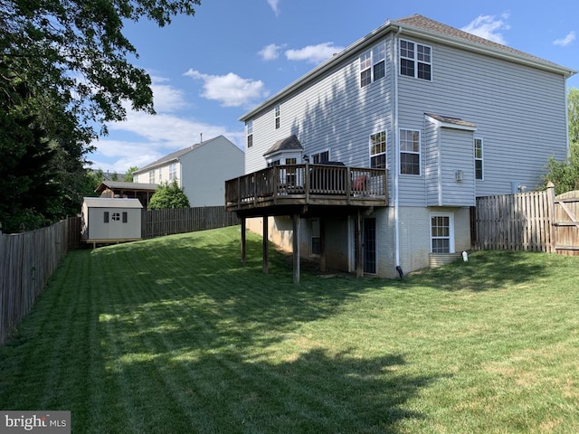 back of property featuring a wooden deck, a yard, and a storage shed