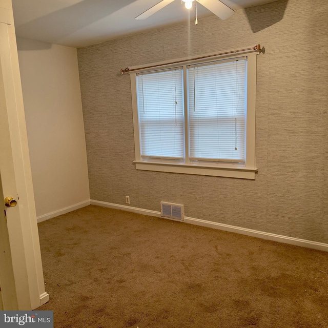 carpeted spare room featuring ceiling fan