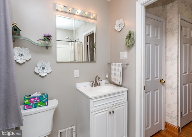 bathroom featuring vanity, hardwood / wood-style floors, and toilet