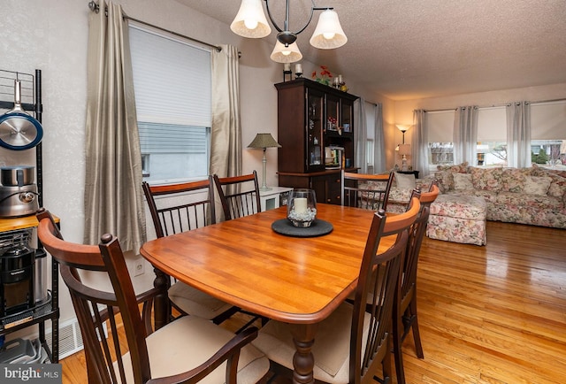 dining room with light hardwood / wood-style floors and a textured ceiling