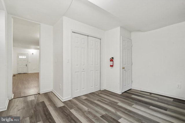 unfurnished bedroom featuring dark wood-type flooring and a closet