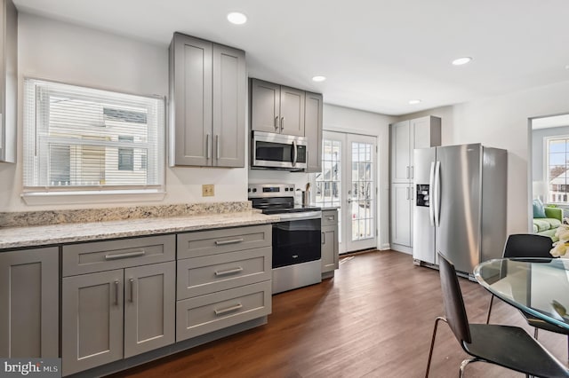 kitchen with appliances with stainless steel finishes, gray cabinetry, and a healthy amount of sunlight