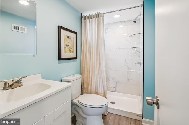 full bathroom featuring visible vents, toilet, a stall shower, wood finished floors, and vanity