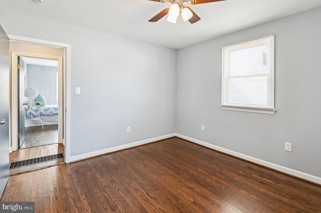 spare room featuring ceiling fan, baseboards, and wood finished floors