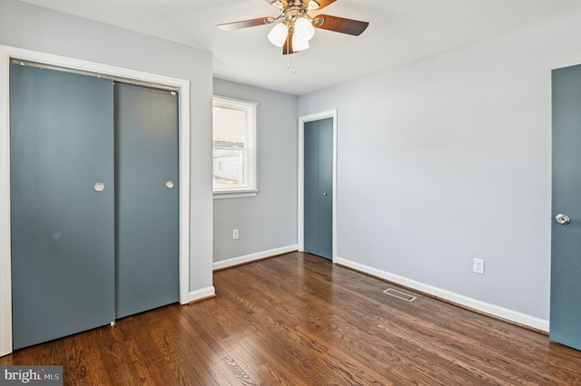 unfurnished bedroom with visible vents, ceiling fan, baseboards, wood finished floors, and a closet
