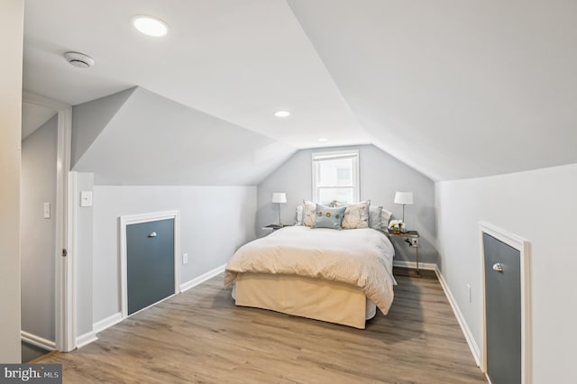 bedroom featuring lofted ceiling, recessed lighting, wood finished floors, and baseboards