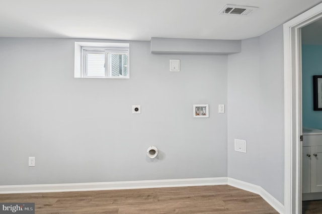 clothes washing area with baseboards, washer hookup, laundry area, wood finished floors, and electric dryer hookup
