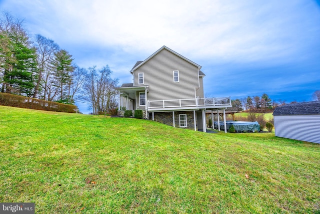 back of property with a wooden deck, a storage shed, and a lawn