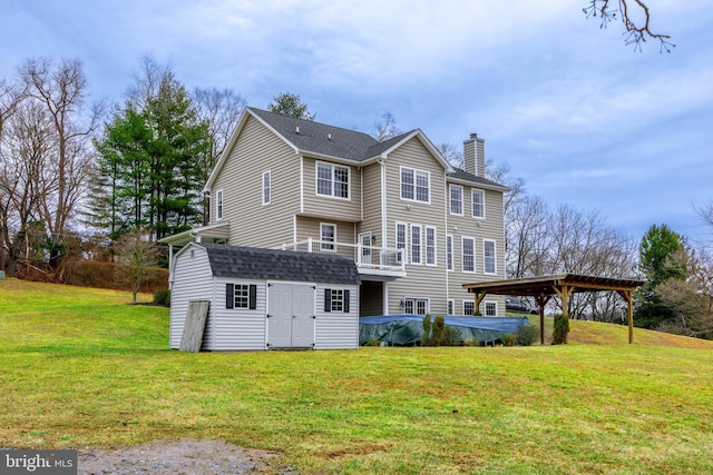 rear view of property with a storage unit and a yard