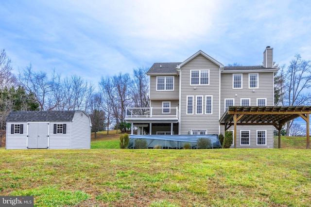 back of property with a wooden deck, a pergola, a lawn, and a storage shed