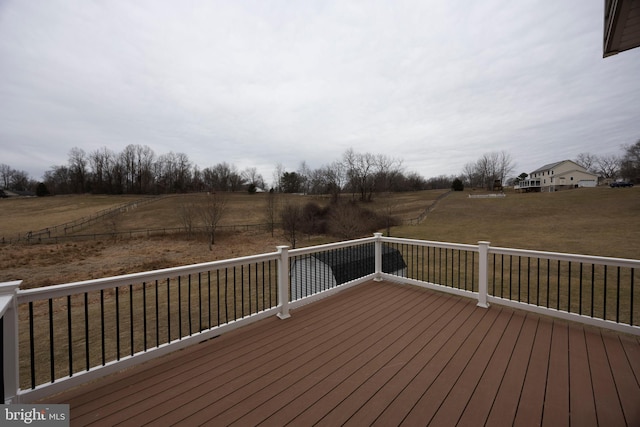 wooden terrace with a yard and a rural view