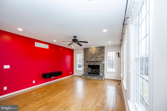 unfurnished living room with ceiling fan, wood-type flooring, and a fireplace