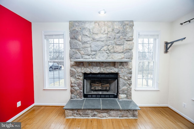 unfurnished living room featuring plenty of natural light, a fireplace, and light hardwood / wood-style floors