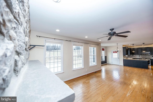 living room featuring hardwood / wood-style floors and ceiling fan with notable chandelier