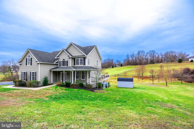 view of front property with a front yard, a porch, and a storage unit