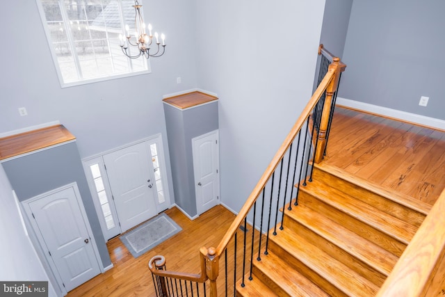 entryway with an inviting chandelier, light hardwood / wood-style flooring, and a high ceiling