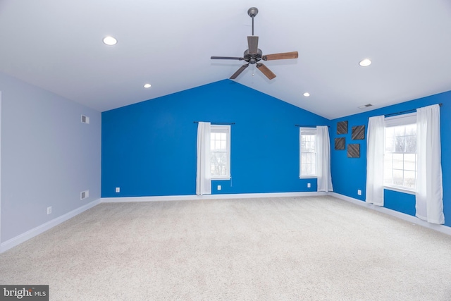 spare room with lofted ceiling, light carpet, and ceiling fan