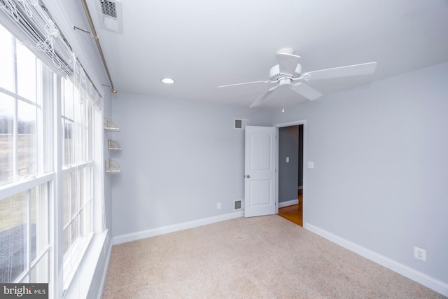 carpeted spare room featuring ceiling fan