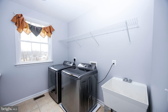 laundry room featuring sink, light tile patterned floors, and washing machine and clothes dryer