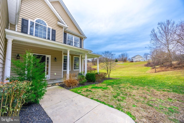 entrance to property with a yard and covered porch