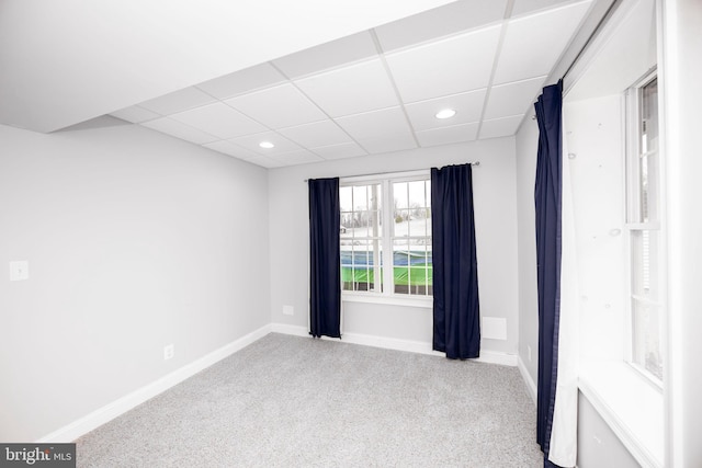 carpeted spare room with a drop ceiling