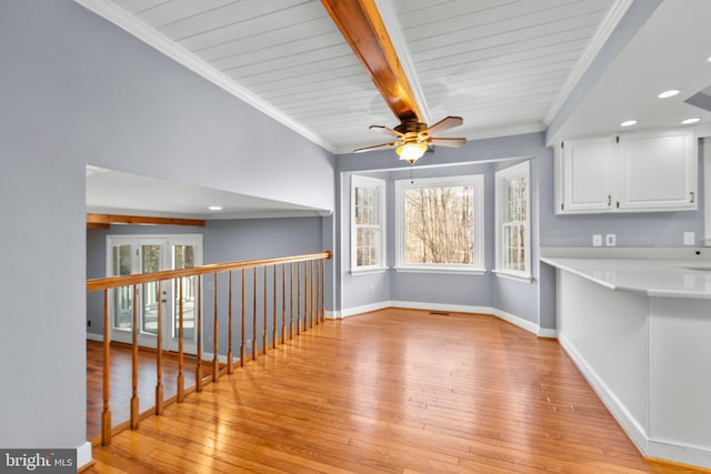 unfurnished dining area featuring beam ceiling, crown molding, recessed lighting, light wood-style flooring, and baseboards