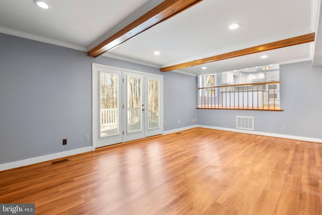 unfurnished living room with beam ceiling, visible vents, and baseboards