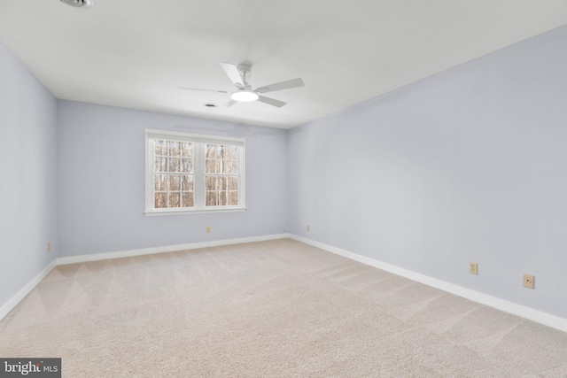 empty room with a ceiling fan, light colored carpet, and baseboards