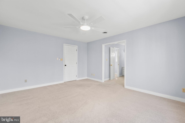 unfurnished room with light carpet, visible vents, baseboards, and a ceiling fan