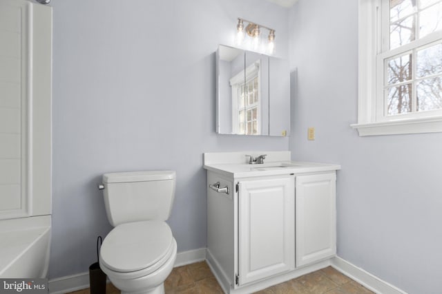 bathroom with toilet, baseboards, and vanity