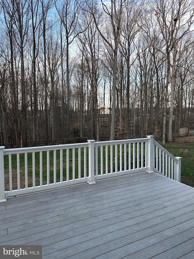 wooden deck featuring a lawn