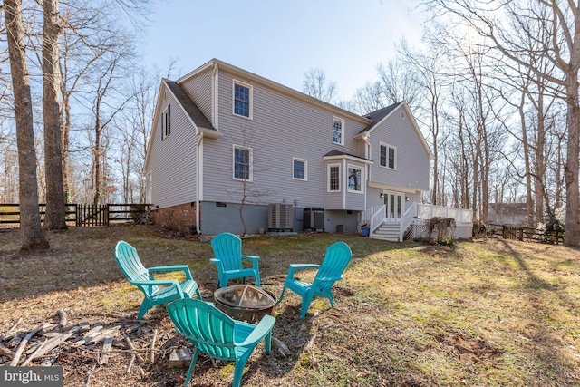 back of property with an outdoor fire pit, fence, and central AC unit