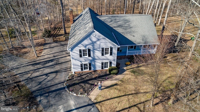 view of front facade with roof with shingles and driveway