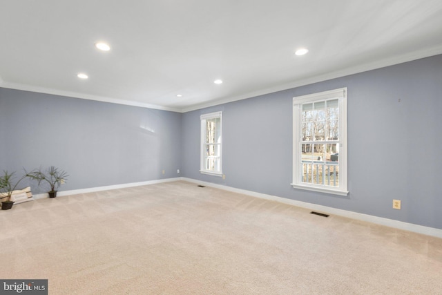 unfurnished room featuring light carpet, baseboards, visible vents, and crown molding