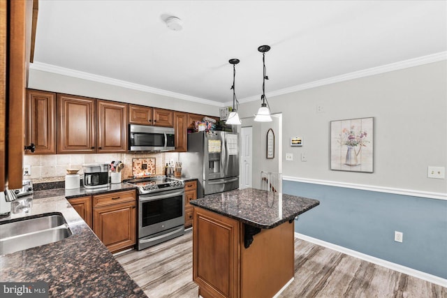 kitchen with pendant lighting, tasteful backsplash, stainless steel appliances, and light hardwood / wood-style floors