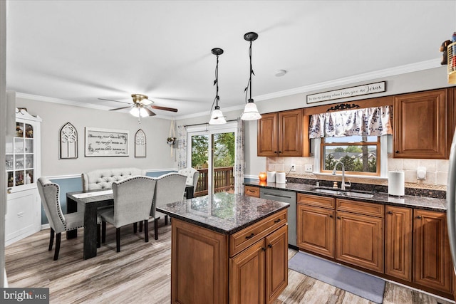 kitchen featuring dark stone countertops, sink, decorative light fixtures, and dishwasher