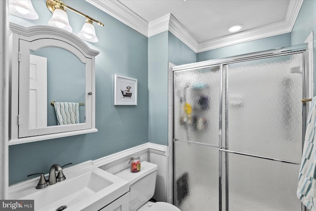 bathroom with vanity, a shower with shower door, ornamental molding, and toilet