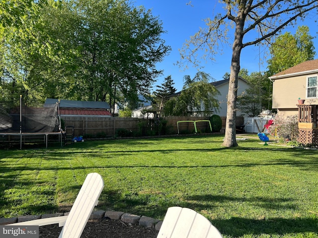 view of yard featuring a playground and a trampoline