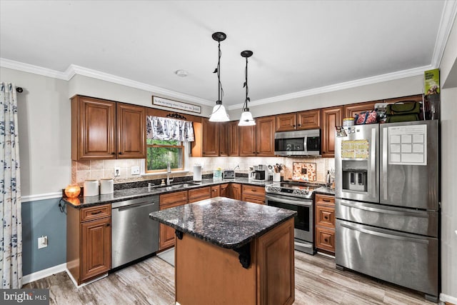 kitchen with tasteful backsplash, sink, hanging light fixtures, a center island, and stainless steel appliances