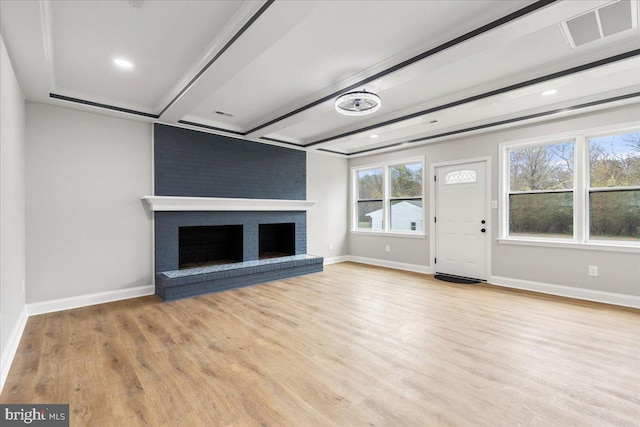 unfurnished living room featuring a fireplace, light hardwood / wood-style floors, and beamed ceiling