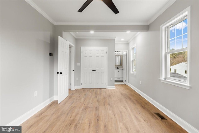 interior space with crown molding, a closet, ensuite bathroom, and light hardwood / wood-style flooring