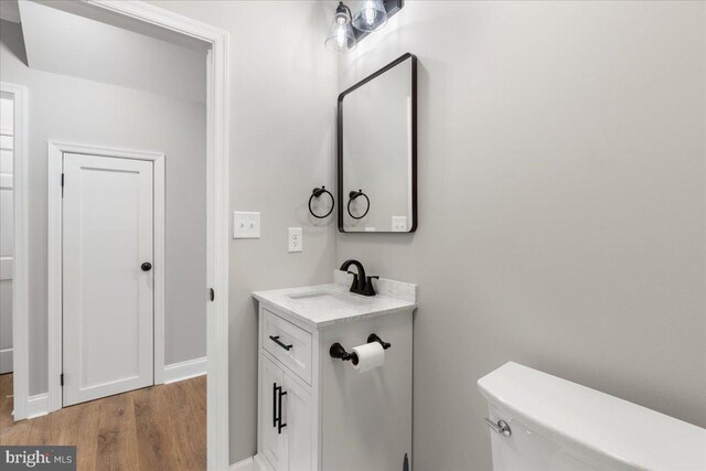 bathroom with vanity, hardwood / wood-style floors, and toilet