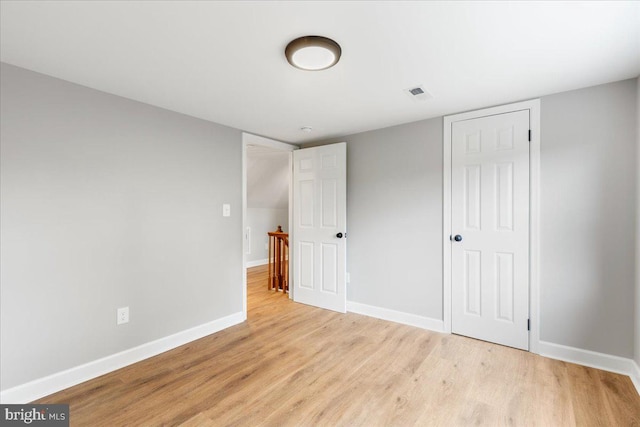 unfurnished bedroom with a closet and light wood-type flooring