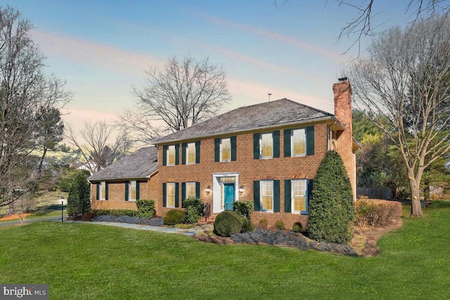 colonial-style house featuring a lawn