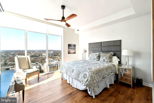 bedroom featuring wood-type flooring, floor to ceiling windows, and ceiling fan